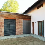 Rodinný dům Počaply – boční pohled na obývací pokoj s plasthliníkovými okny Internorm KF 410 Home Pure a zataženými roletami